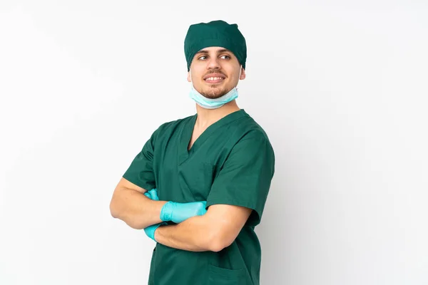 身穿绿色制服的外科医生 与孤独的白色背景隔离 双臂交叉 快乐无比 — 图库照片