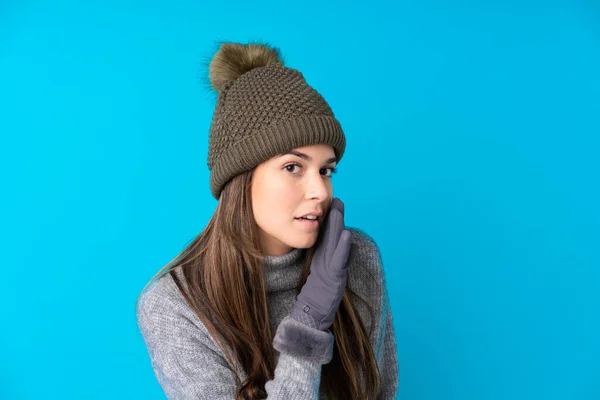 Menina Adolescente Com Chapéu Inverno Sobre Fundo Azul Isolado Sussurrando — Fotografia de Stock