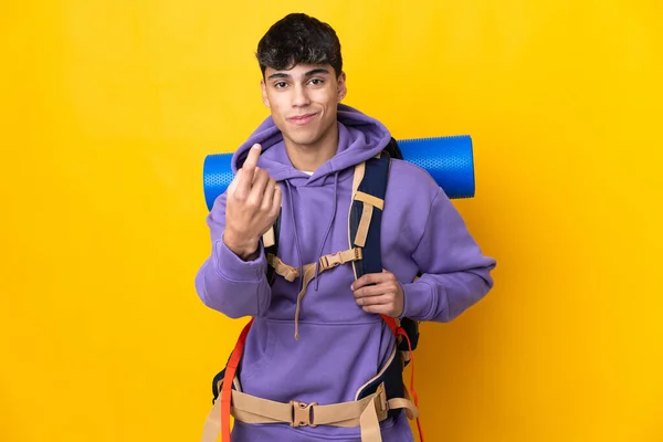 Молодий Альпініст Великим Рюкзаком Над Ізольованим Жовтим Тлом Робить Жест — стокове фото