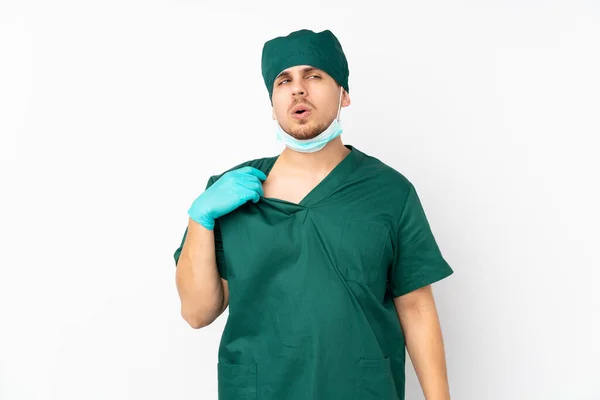 身穿绿色制服的外科医生 被隔离在孤独的白色背景下 疲惫而病态的表情 — 图库照片