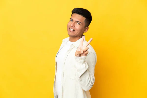 Νεαρός Άνδρας Του Εκουαδόρ Απομονωμένος Κίτρινο Φόντο Χαμογελώντας Και Δείχνοντας — Φωτογραφία Αρχείου
