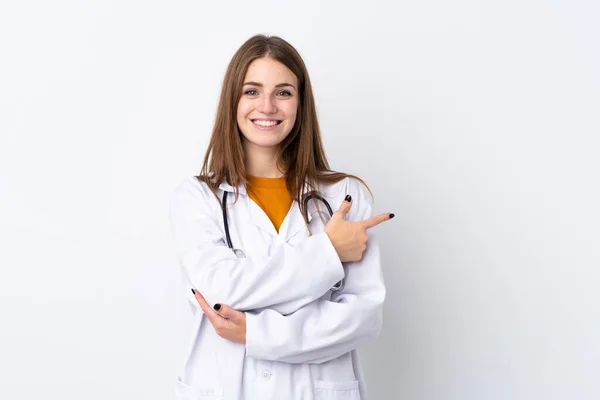 Junge Frau Mit Isoliertem Hintergrund Trägt Arztkittel Und Zeigt Auf — Stockfoto