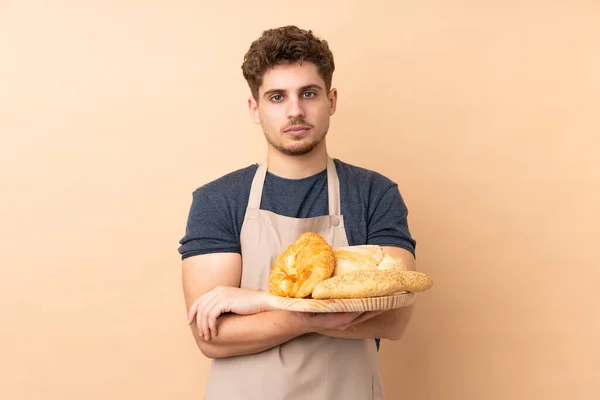 Männlicher Bäcker Hält Einen Tisch Mit Mehreren Broten Isoliert Auf — Stockfoto