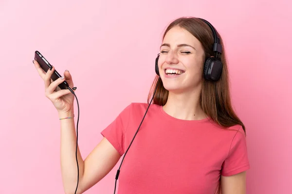 Giovane Donna Sfondo Rosa Isolato Ascoltare Musica Fare Gesto Chitarra — Foto Stock