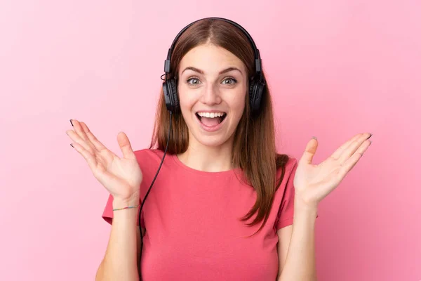 Young Woman Isolated Pink Background Surpeised Listening Music — Stok fotoğraf