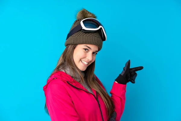 Nastoletnia Narciarka Okularach Snowboardowych Odizolowanym Niebieskim Tle Wskazującym Palcem Bok — Zdjęcie stockowe