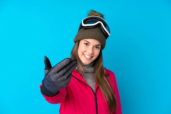 青少年滑雪者女孩带着雪板眼镜与孤立的蓝色背景邀请来 — 图库照片