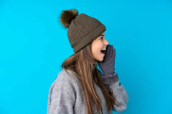 Teenager Dívka Zimní Klobouk Přes Izolované Modré Pozadí Křičí Ústy — Stock fotografie