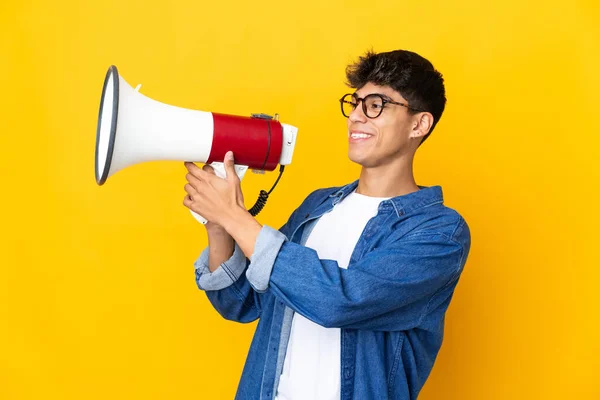 Jovem Sobre Fundo Amarelo Isolado Gritando Através Megafone Para Anunciar — Fotografia de Stock