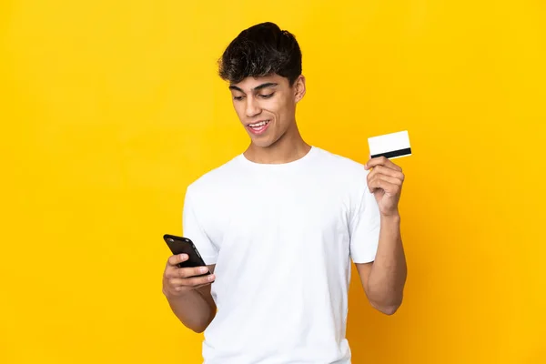Fiatal Férfi Több Mint Elszigetelt Sárga Háttér Vásárlás Mobil Hitelkártyával — Stock Fotó