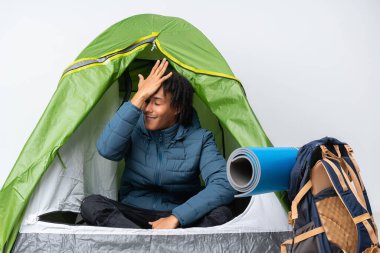 Genç Afrikalı Amerikalı bir adam yeşil çadırın içinde bir şey fark etti ve çözüme niyetlendi.