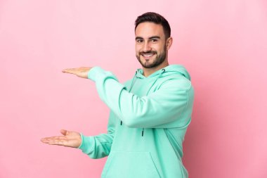 Beyaz tenli yakışıklı, pembe arka planda izole edilmiş. Kopyalama alanı var. Bir ilan vermek için.