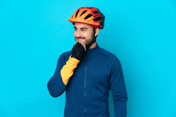 Joven Ciclista Aislado Sobre Fondo Azul Mirando Hacia Lado Sonriendo — Foto de Stock