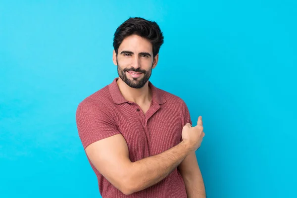 Joven Hombre Guapo Con Barba Sobre Fondo Azul Aislado Apuntando —  Fotos de Stock