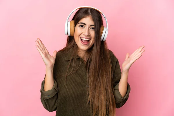 Giovane Donna Caucasica Isolata Sfondo Rosa Sorpreso Ascoltare Musica — Foto Stock