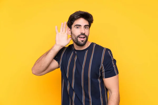 Joven Hombre Guapo Con Barba Sobre Fondo Amarillo Aislado Escuchando — Foto de Stock