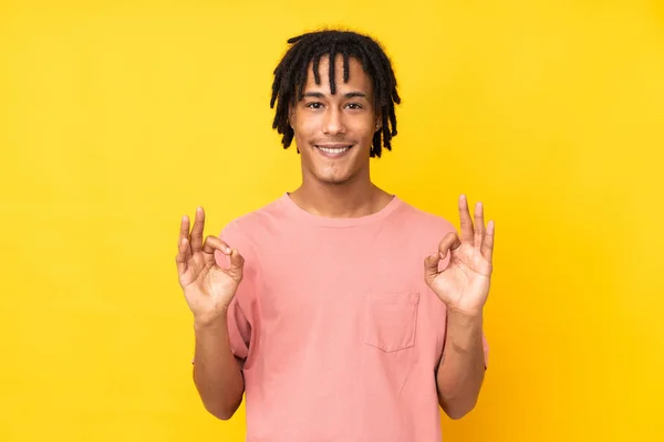 아프리카계 미국인 남자노란 배경에 손가락으로 사인을 — 스톡 사진