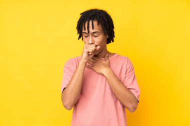 Sarı arka planda izole edilmiş genç Afro-Amerikan adam öksürük ve kötü hissediyor.