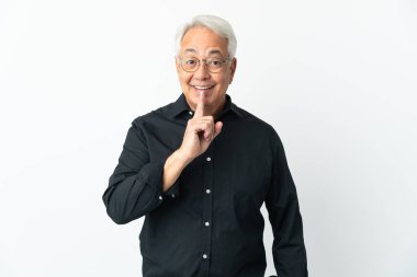 Beyaz arka planda izole edilmiş orta yaşlı Brezilyalı bir adam sessizlik işareti gösteriyor. Parmağını ağzına sokuyor.