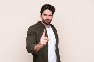 Sakallı, sakallı, soyutlanmış, hayal kırıklığına uğramış ve ön tarafı işaret eden genç bir adam.