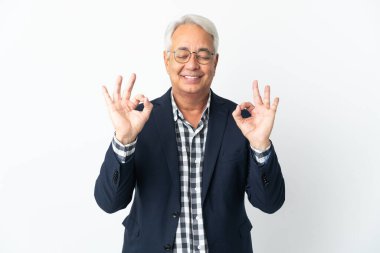 Orta yaşlı Brezilyalı erkek Zen pozunda beyaz arka planda izole edilmiş.