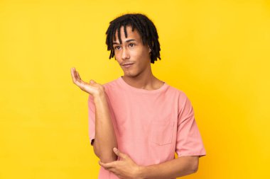 Sarı arka planda izole edilmiş genç Afro-Amerikan bir şeyi anlamadığı için mutsuz.