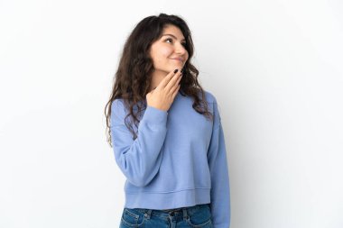 Genç Rus kız beyaz arka planda izole edilmiş gülümserken yukarı bakıyor.