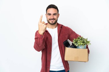 Beyaz arka planda izole edilmiş eşyalarla dolu bir kutuyu alırken beyaz bir adam hamle yapıyor.