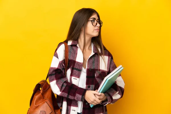 Jovem Estudante Mulher Isolada Fundo Amarelo Olhando Para Lado — Fotografia de Stock