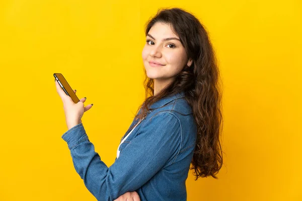 Έφηβος Ρωσίδα Απομονωμένη Κίτρινο Φόντο Κρατώντας Ένα Κινητό Τηλέφωνο Και — Φωτογραφία Αρχείου