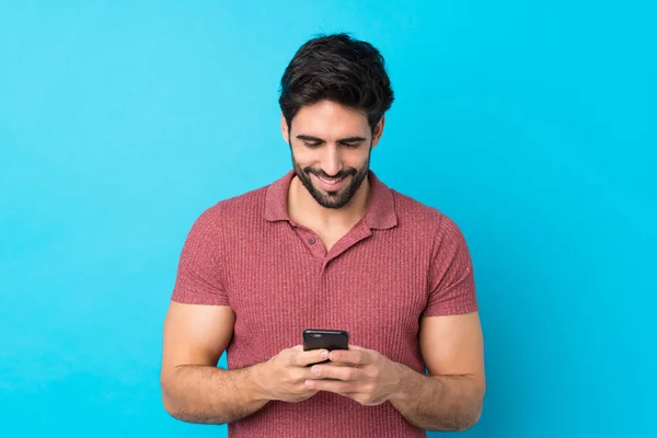 Молодой Красивый Мужчина Бородой Изолированном Синем Фоне Отправляет Сообщение Мобильным — стоковое фото