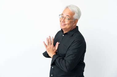 Orta yaşlı Brezilyalı bir adam beyaz arka planda bir şeyler çeviriyor.