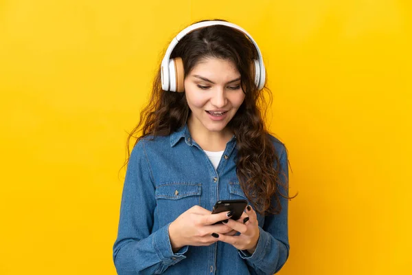 Adolescente Ragazza Russa Isolata Sfondo Giallo Ascoltare Musica Guardando Cellulare — Foto Stock