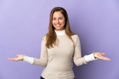 Orta yaşlı Brezilyalı kadın, mor arka planda izole edilmiş, kuşkuları var.