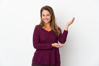 Orta yaşlı Brezilyalı bir kadın beyaz arka planda izole edilmiş ve davet edilmek için ellerini yana uzatıyor.