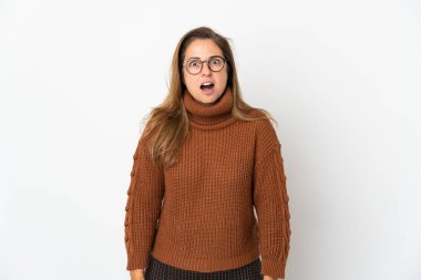 Orta yaşlı Brezilyalı bir kadın, beyaz arka planda izole edilmiş, şaşırmış bir yüz ifadesi var.