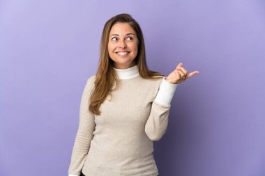 Mor arka planda izole edilmiş orta yaşlı Brezilyalı kadın parmağını kaldırarak çözümü bulmaya çalışıyor.