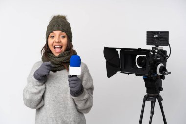 Elinde mikrofon olan gazeteci kadın, izole edilmiş beyaz bir arkaplanda, şaşırmış ve ön tarafı işaret ediyor.