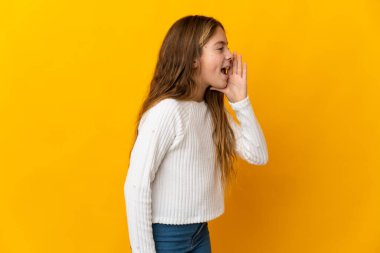 İzole edilmiş sarı arka planda çocuk ağzı sonuna kadar açık bağırıyor.