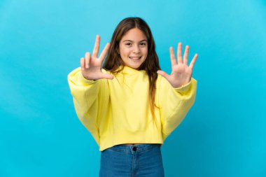 Küçük kız mavi arka planda, parmaklarıyla sekiz sayıyor.