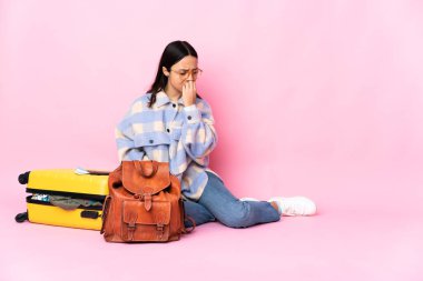 Elinde bavuluyla yerde oturan gezgin kadının şüpheleri var.