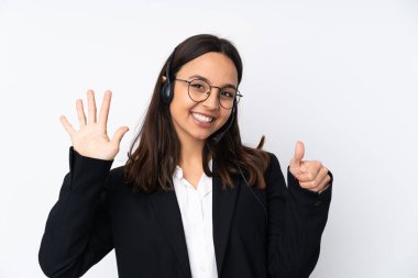 Beyaz arka planda izole edilmiş genç pazarlamacı kadın parmaklarıyla altı kişi sayıyor.