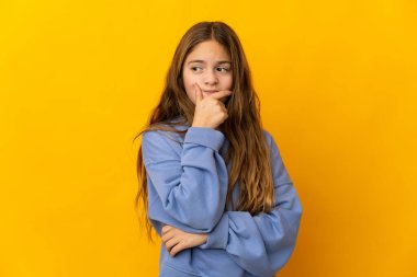 İzole edilmiş sarı arka plan üzerinde şüpheleri olan çocuk