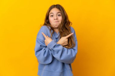 İzole edilmiş sarı arka plandaki çocuk, yan taraftakilerin şüphelerine işaret ediyor