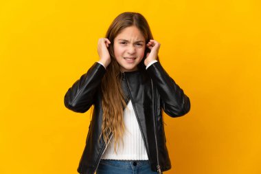 İzole edilmiş sarı arka plandaki çocuk hayal kırıklığına uğramış ve kulaklarını kapatmış