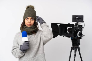 Muhabir kadın mikrofon tutuyor ve izole edilmiş beyaz bir arkaplandan haber veriyor. Şüpheleri var ve düşünüyor.