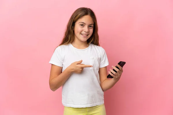 전화를 사용하여 그것을 가리키는 분홍색 배경을 어린이 — 스톡 사진