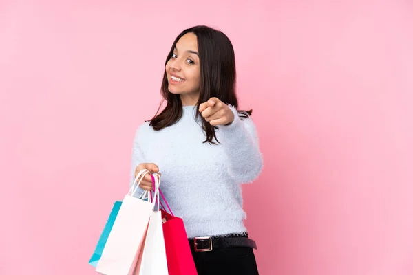 若いです女性でショッピングバッグ以上隔離されたピンクの背景作る電話ジェスチャーと指摘フロント — ストック写真