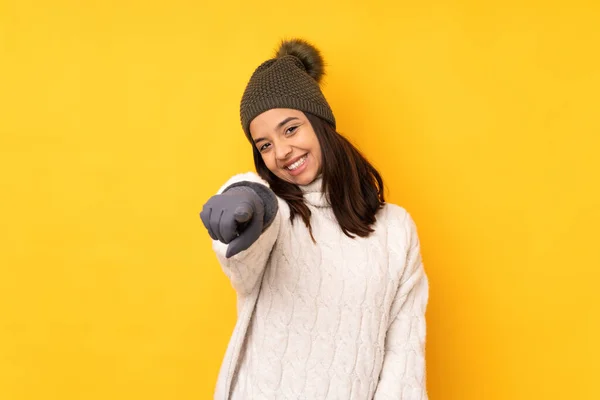 年轻女人戴着冬帽 披着孤立的黄色背景 带着自信的表情指着你 — 图库照片