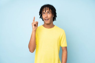 Genç Afrikalı Amerikalı bir adam mavi arka planda izole edilmiş.